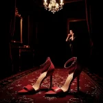 Dramatic shot of red high heels on a luxurious rug in a grand hall, capturing bridal fashion details for a wedding by Chaplin Studio.