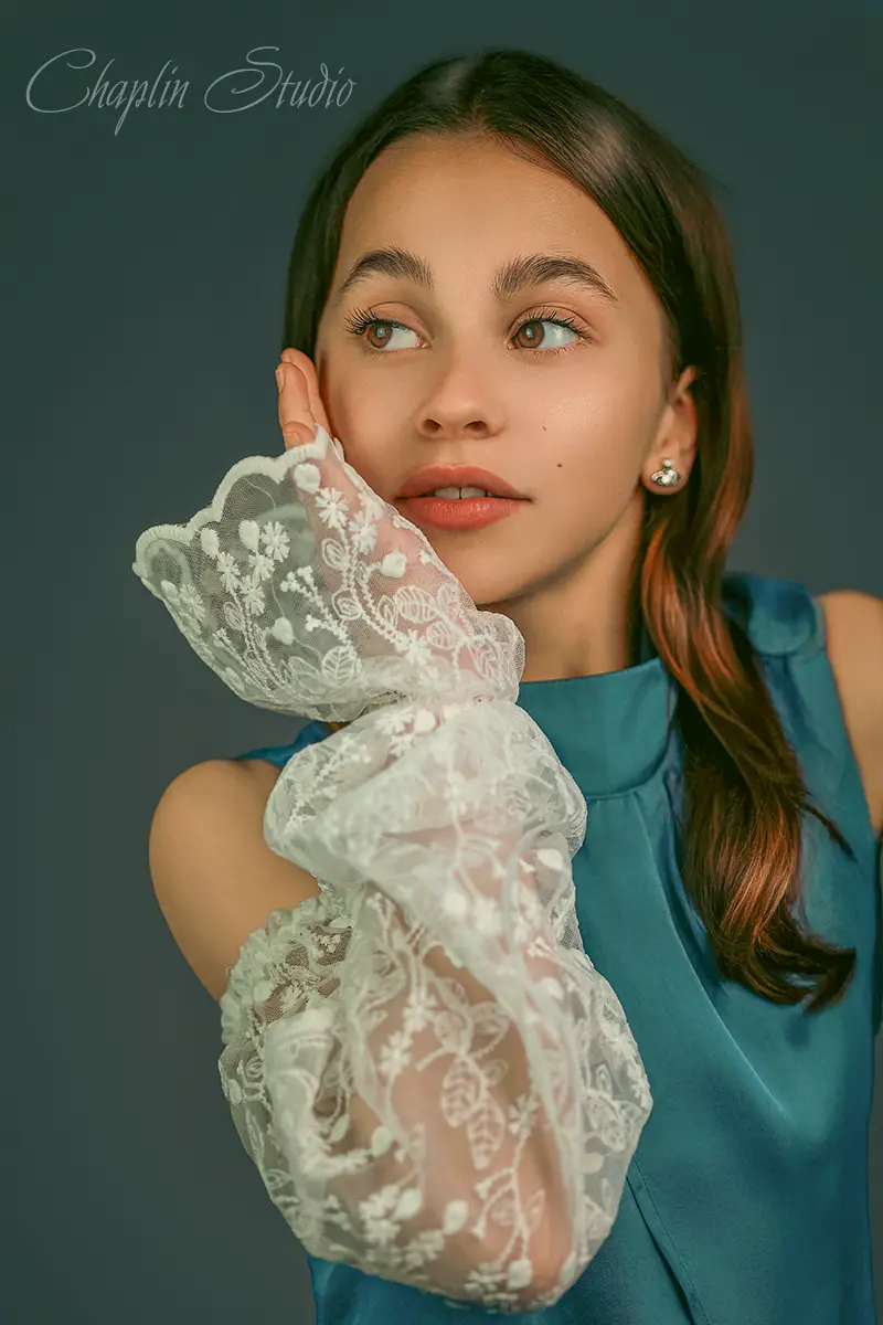 Fine art portrait of a girl in a blue dress with white lace sleeves. Creative photography by Chaplin Studio