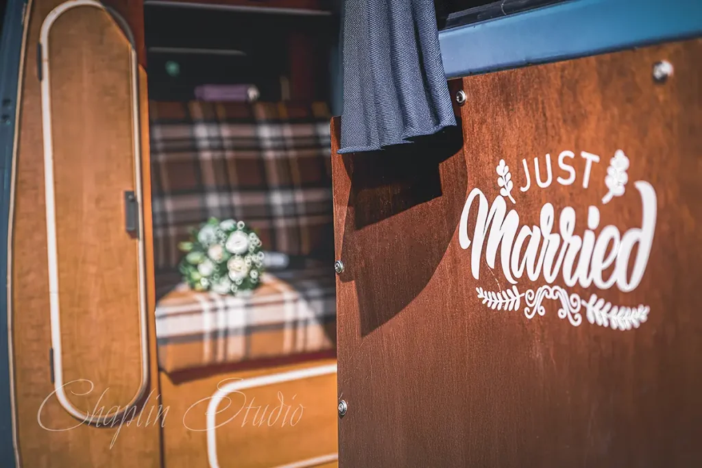 'Just Married' camper van featuring a wedding bouquet on the plaid seat, captured by Chaplin Studio for adventurous Yorkshire wedding photography.